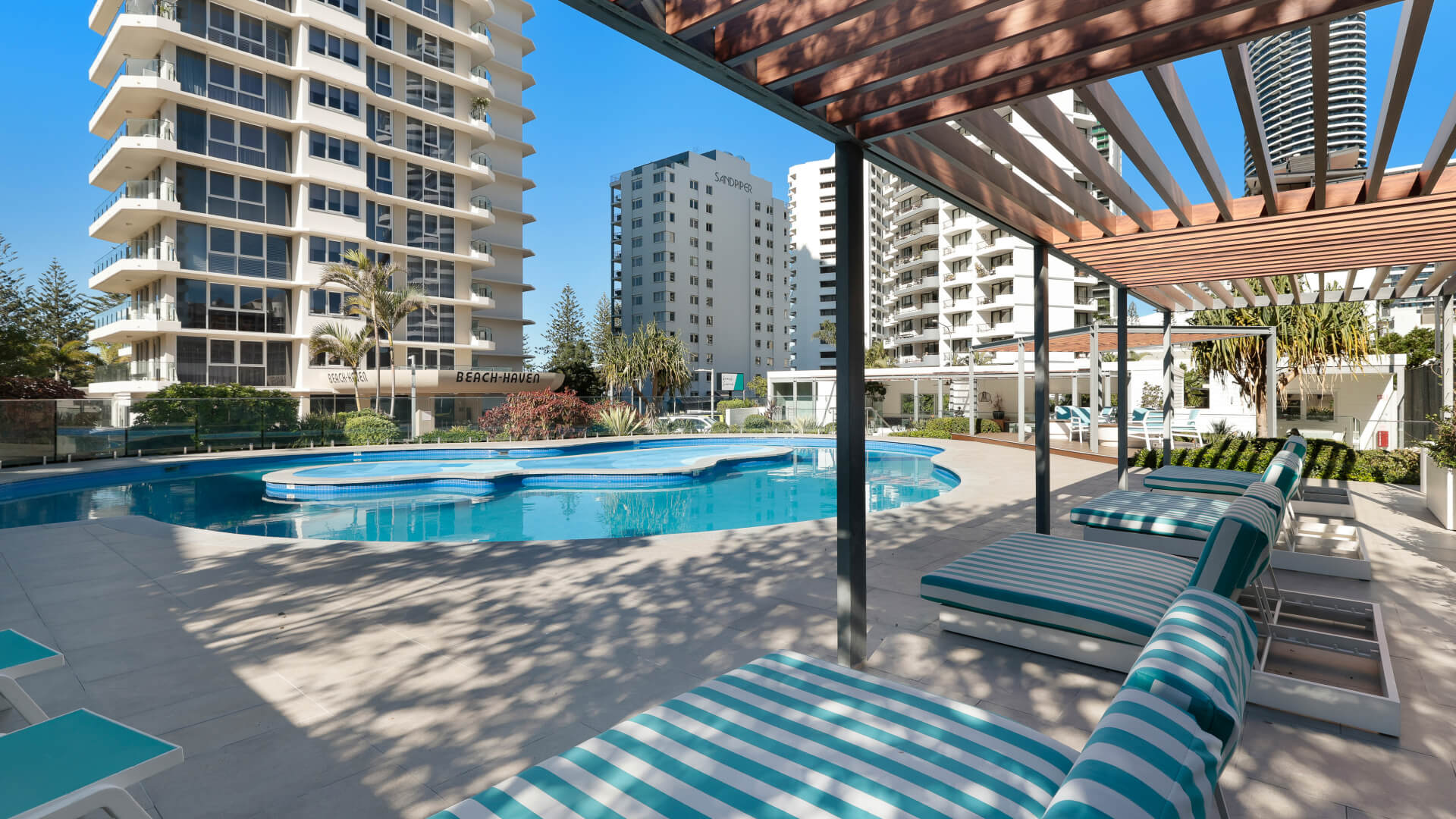 Wide shot of the pool and sun lounges under the shade at ULTIQA Beach Haven