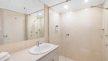 Contemporary bathroom with walk-in shower at ULTIQA Beach Haven on Broadbeach.