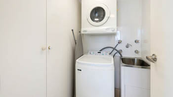 Spacious bathroom with vanity, toilet and large mirror at ULTIQA Beach Haven on Broadbeach.