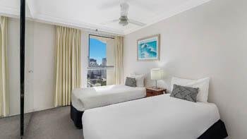 Twin bedroom with city skyline views and natural light at ULTIQA Beach Haven on Broadbeach.