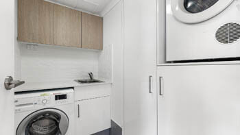 In-apartment laundry with washer, dryer and storage at ULTIQA Beach Haven on Broadbeach.