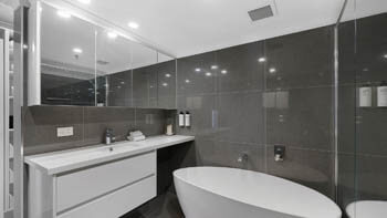 Stylish bathroom with freestanding bathtub at ULTIQA Beach Haven on Broadbeach.