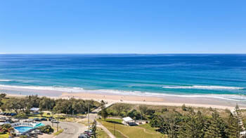 Living room with modern leather furniture, tv and stunning view of Gold Coast and ocean at ULTIQA Beach Haven on Broadbeach.