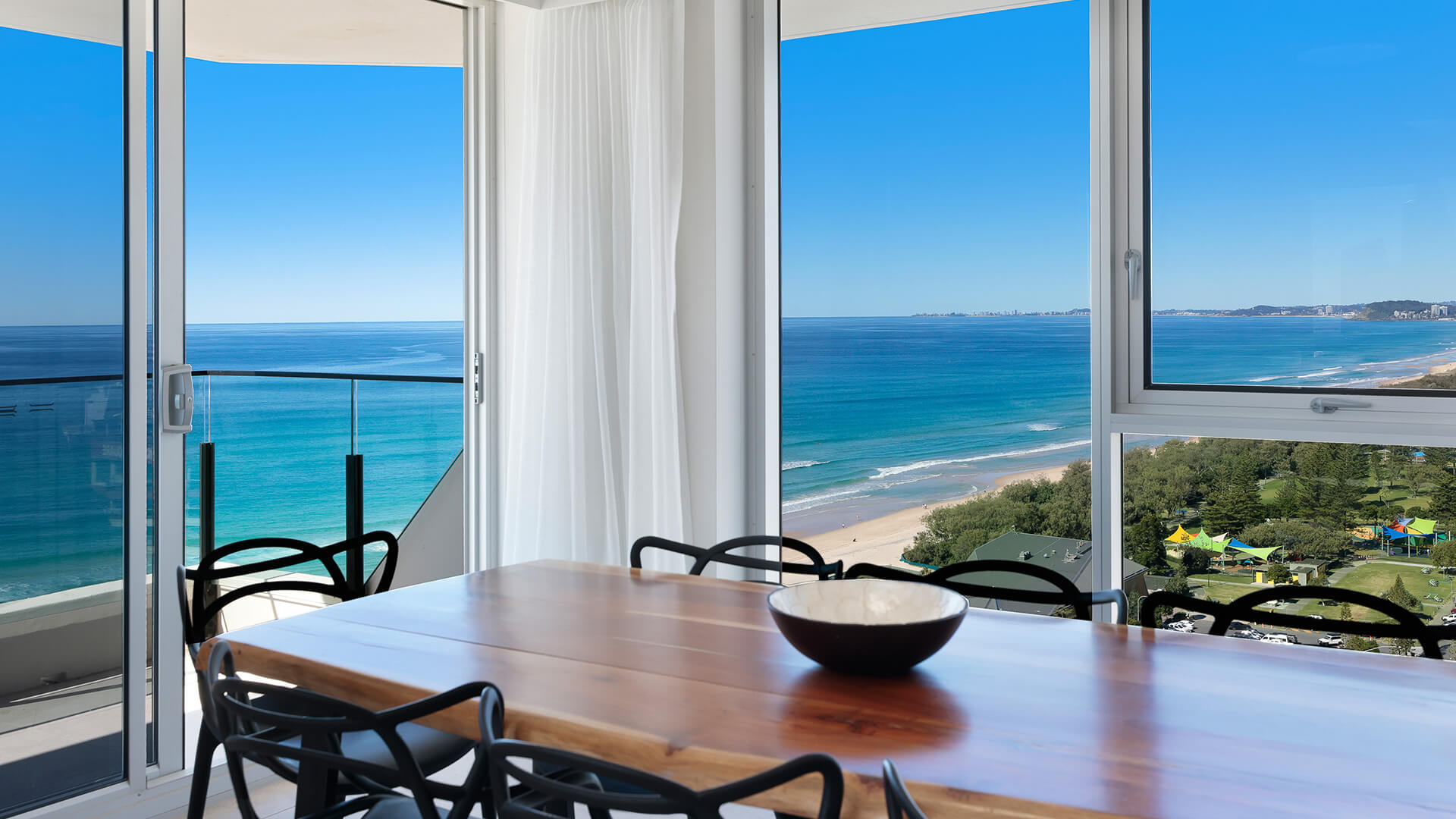 Dining table with ocean and coastline views in ULTIQA Beach Haven on Broadbeach, Surfers Paradise.