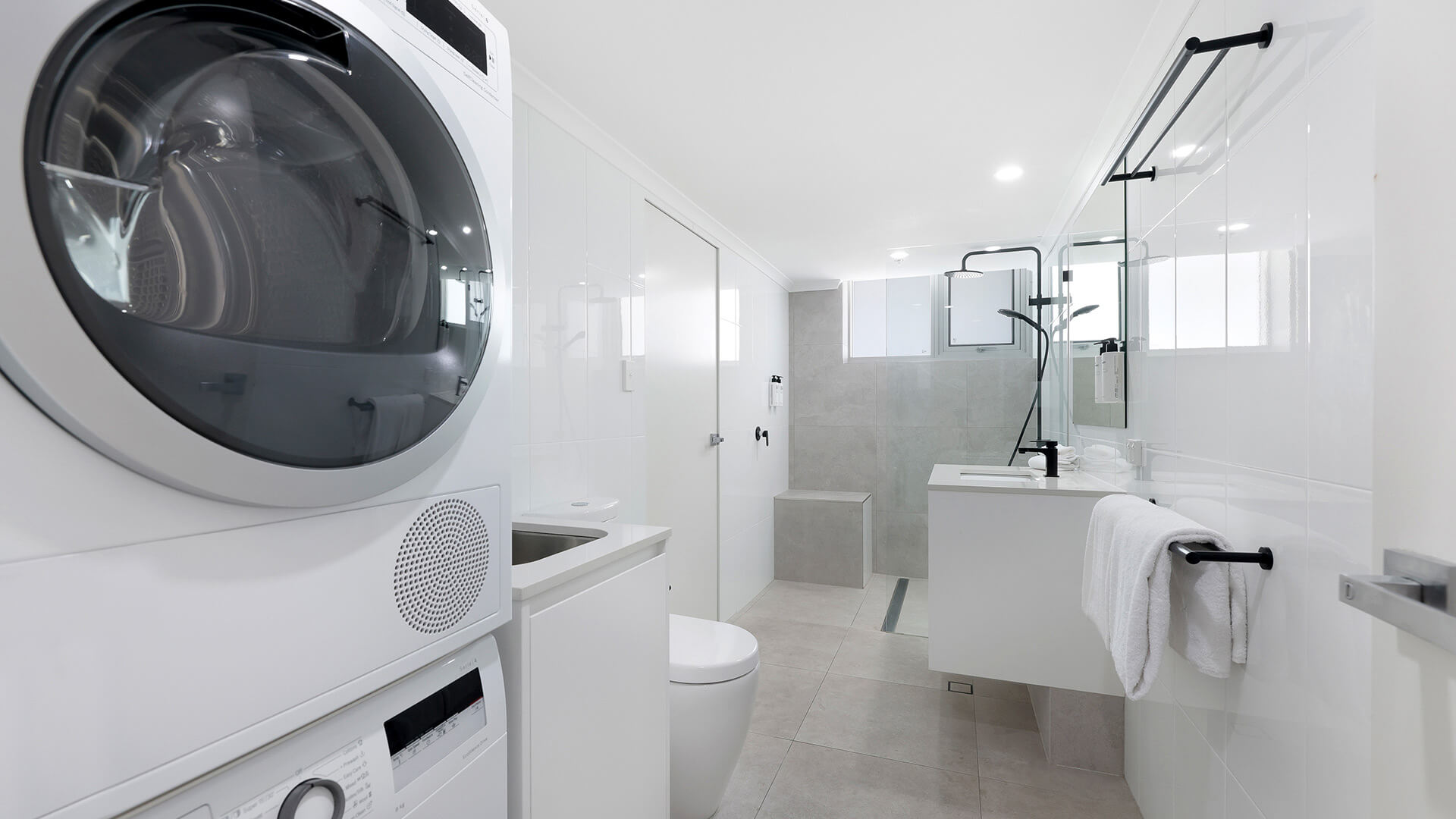 Spacious bathroom with washer and dryer plus walk-in shower at ULTIQA Beach Haven on Broadbeach, Gold Coast accommodation.