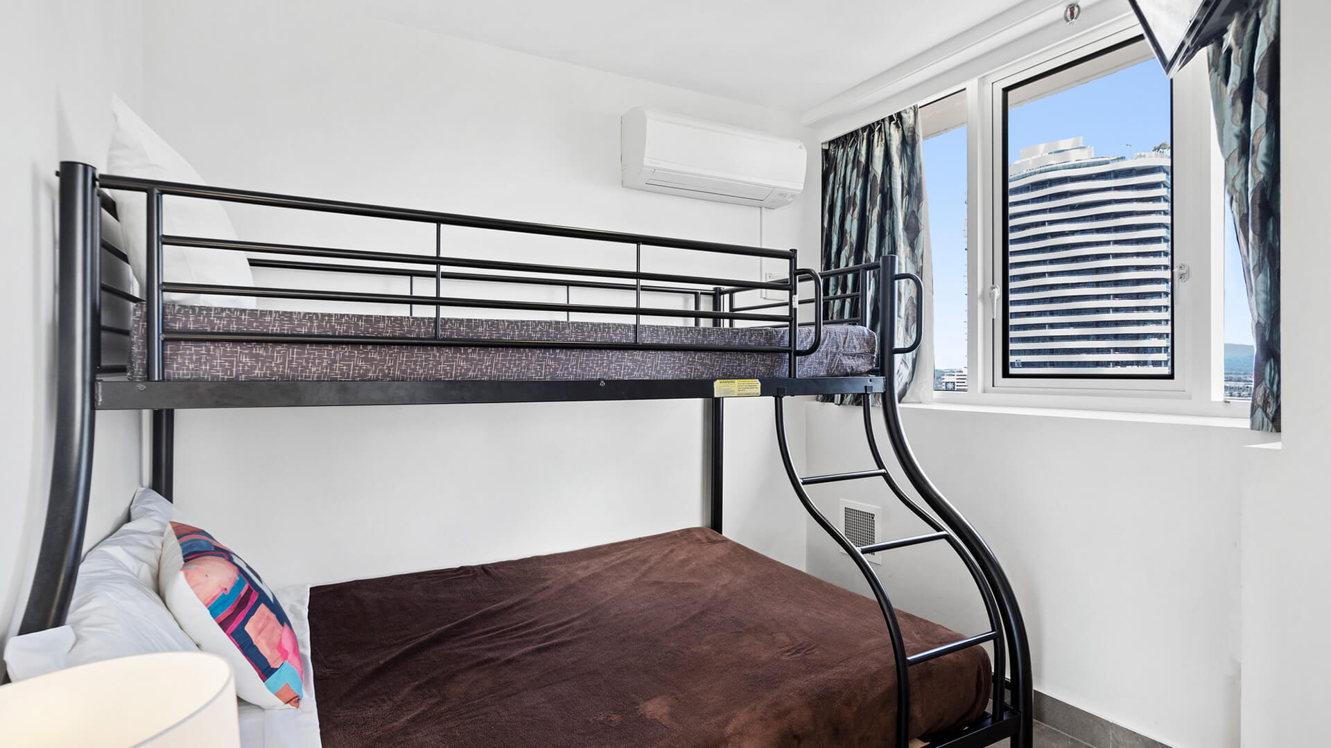 Third bedroom with white walls, bunk beds and a window at ULTIQA Beach Haven on Broadbeach.