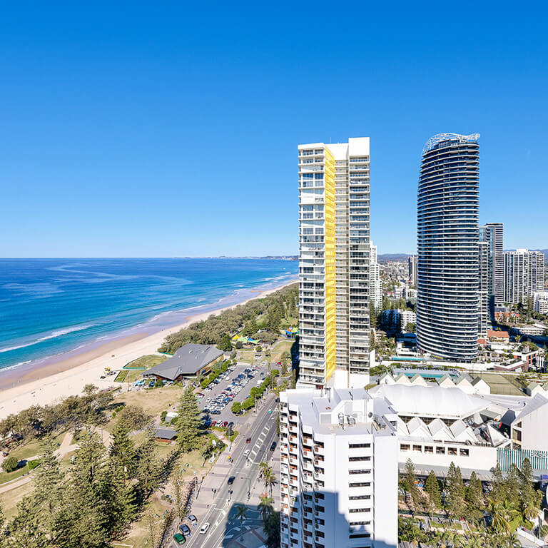 Couple arriving at the ULTIQA resort lobby, holding hands and smiling as they approach reception.